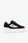 Black sneaker with a white sole on a light gray background